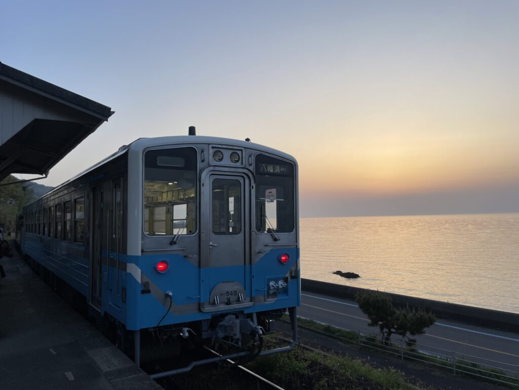 夕日と下灘駅に停車する電車